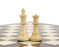 Hand carved boxwood Staunton king and queen chess pieces on a black and white chessboard